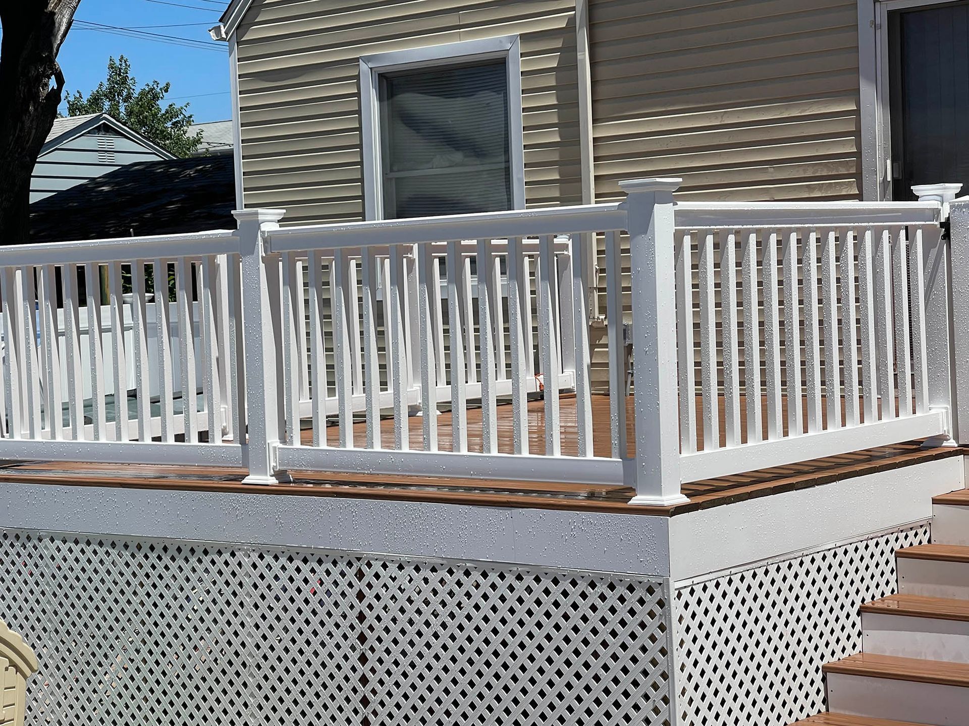 A deck with a white railing and stairs leading up to it