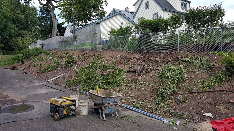 A wheelbarrow is sitting on the side of a road next to a generator.