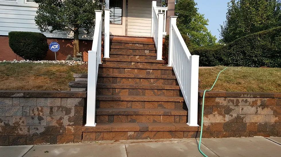 A set of stairs leading up to a house with a white railing
