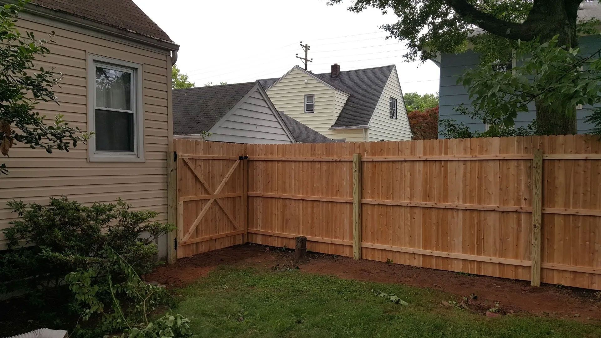 A wooden fence is in the backyard of a house