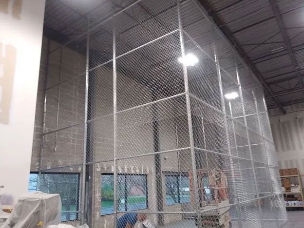 A large room with a cage in the middle of it
