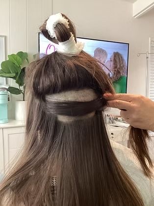 Hair being sectioned with a clip during a salon-style styling process.
