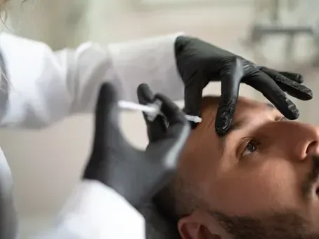 Close-up of a doctor marking a man’s forehead with a surgical pen before a procedure