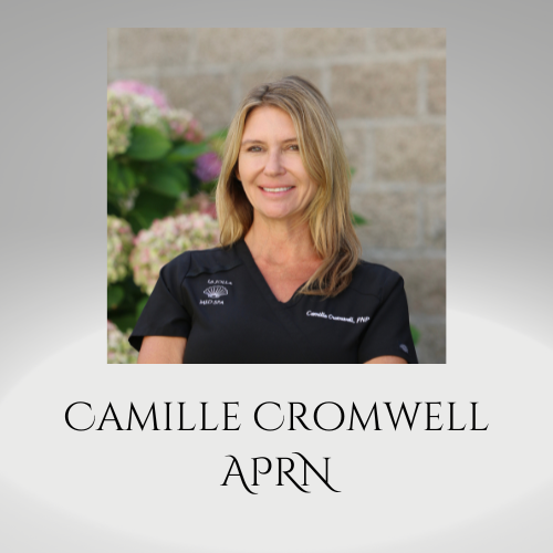 Portrait of Camille Cromwell in black scrubs, smiling outdoors with flowers and a stone wall behind her