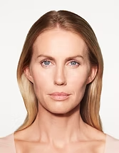 Studio portrait of a person with straight blonde hair, facing forward against a white background, neutral expression