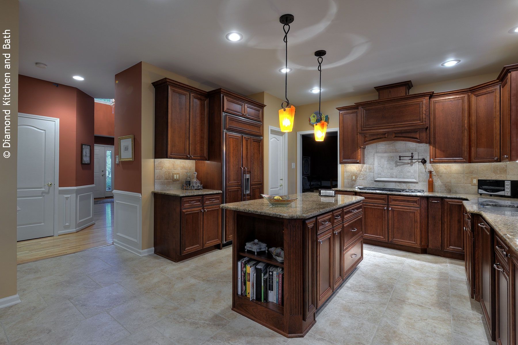 Spacious kitchen with dark wood cabinets, granite countertops, island, and pendant lights