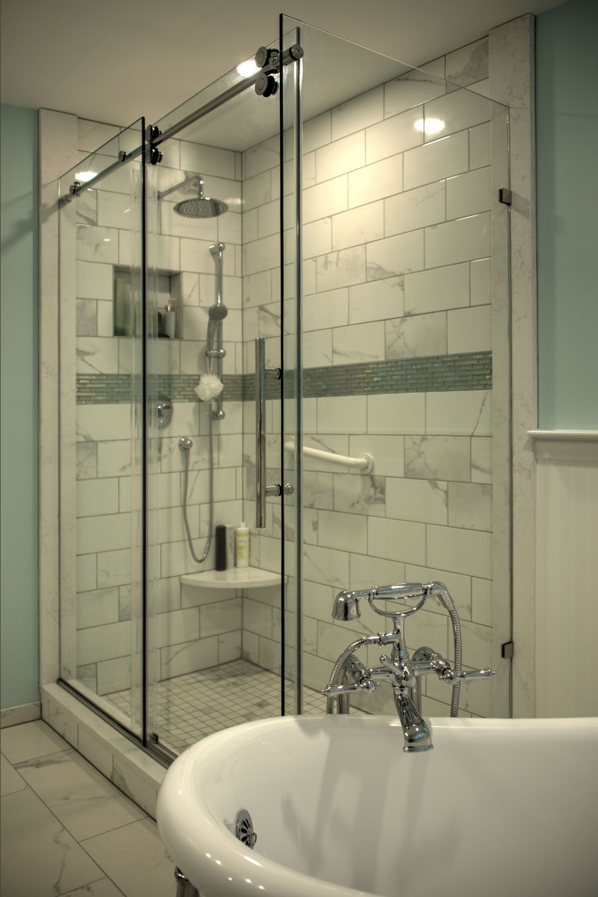 Glass shower with marble tile interior and a soaking tub