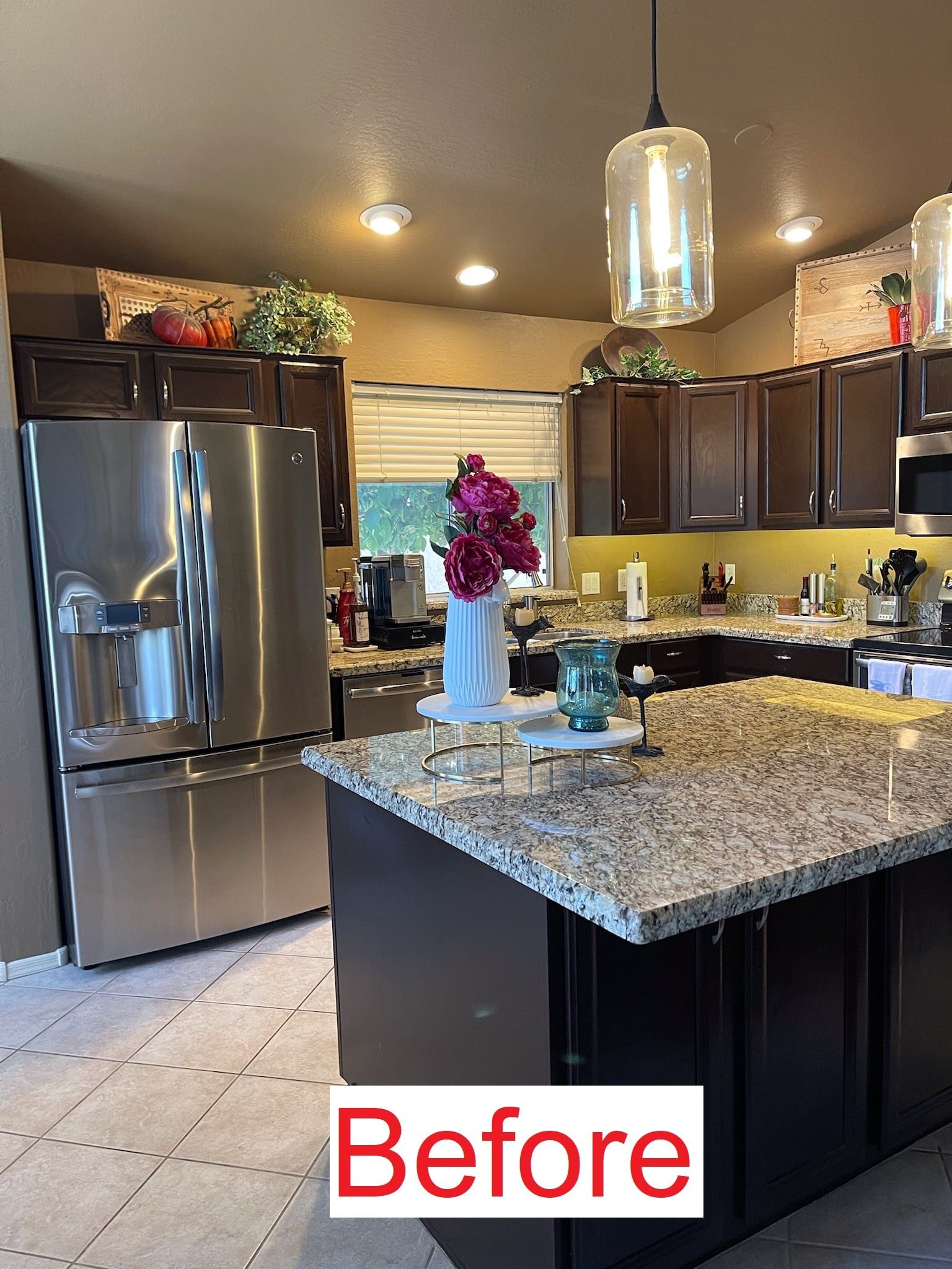 Kitchen with dark brown cabinets, stainless steel appliances, granite countertops, and a center island