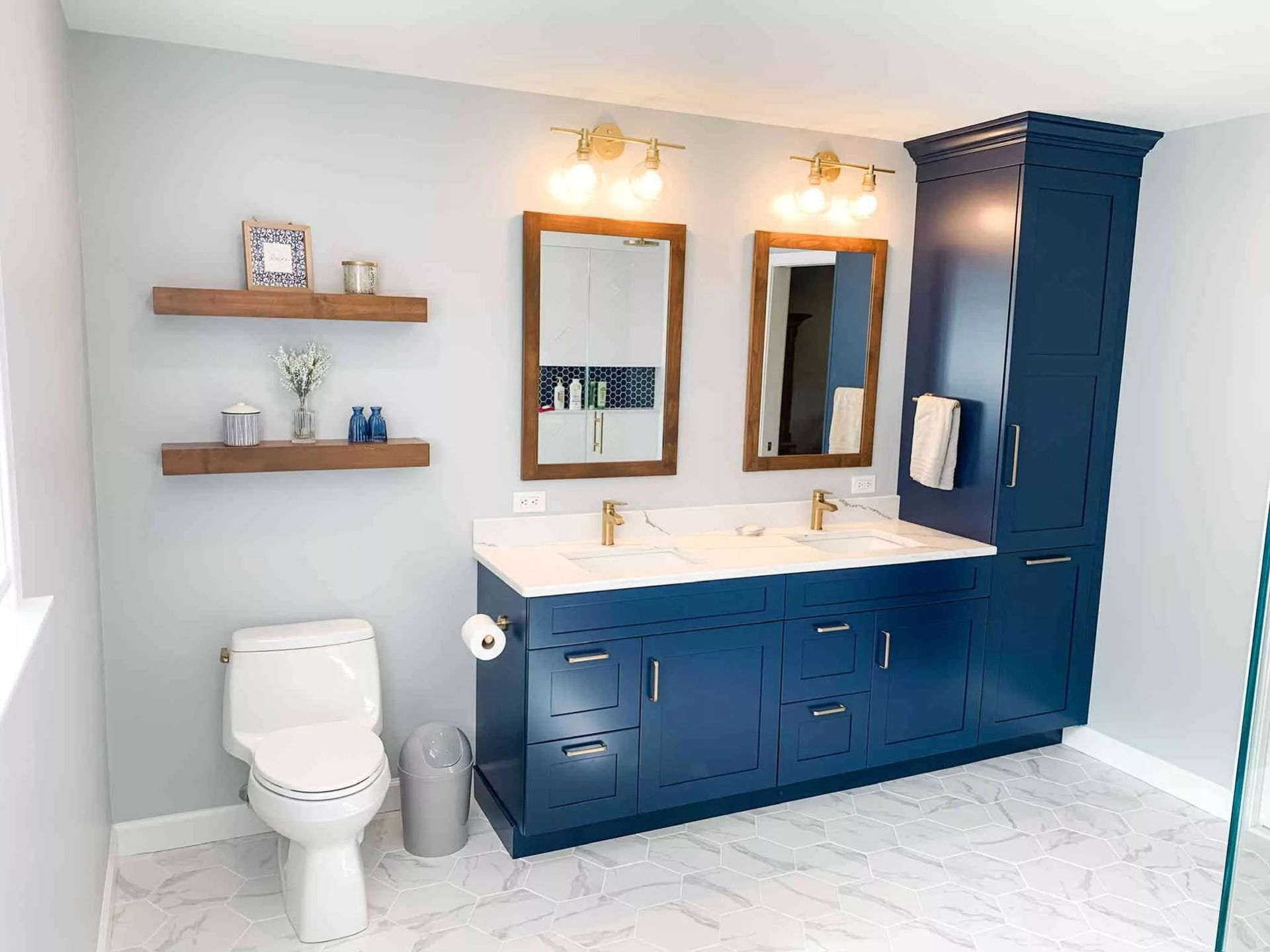 Bathroom with blue vanity, white countertop, gold fixtures, and gray walls