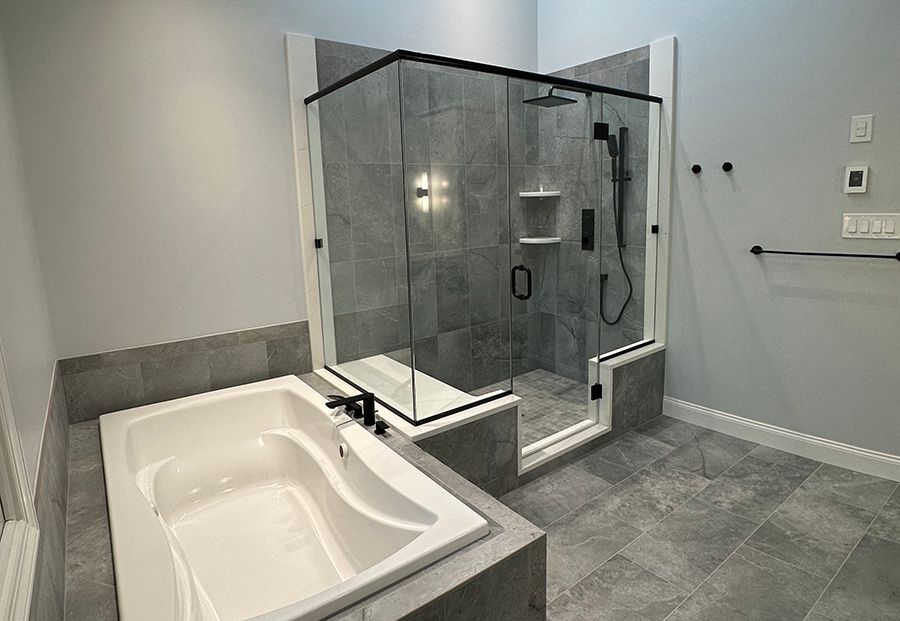 Modern bathroom with gray tile, shower, and bathtub