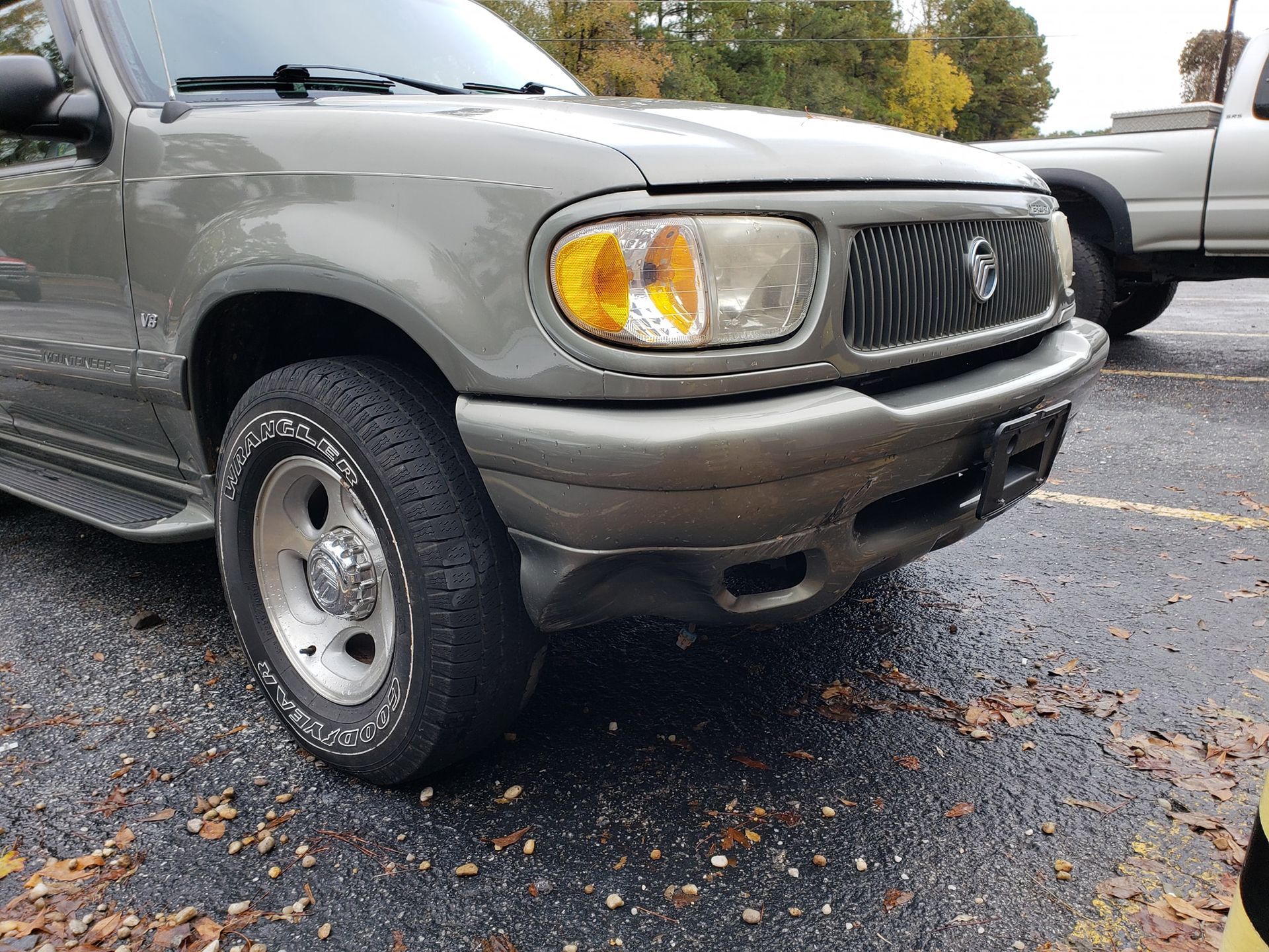 Green Mercury SUV, front view, in a parking lot on an overcast day.
