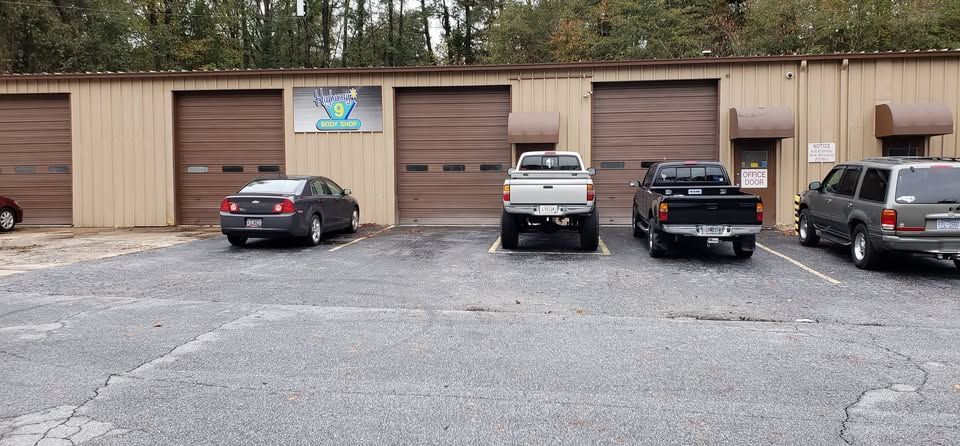 Exterior view of a building with brown garage doors and parked vehicles.