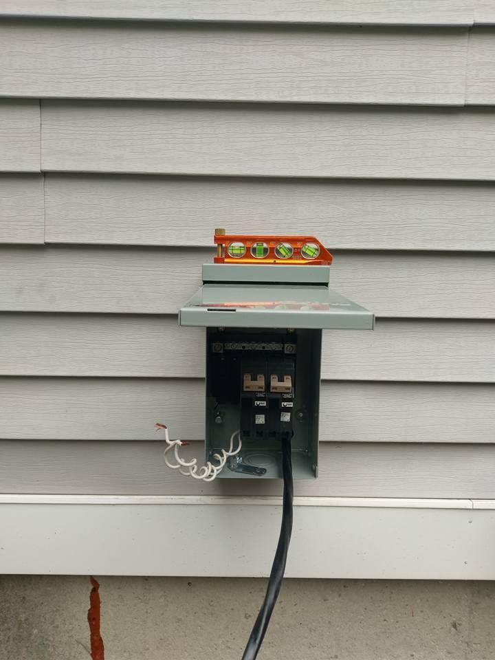 A power outlet on the side of a house with a level on top of it.