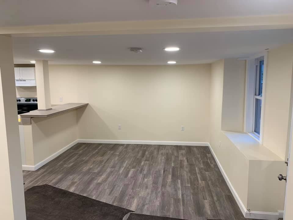 A living room with hardwood floors and white walls.