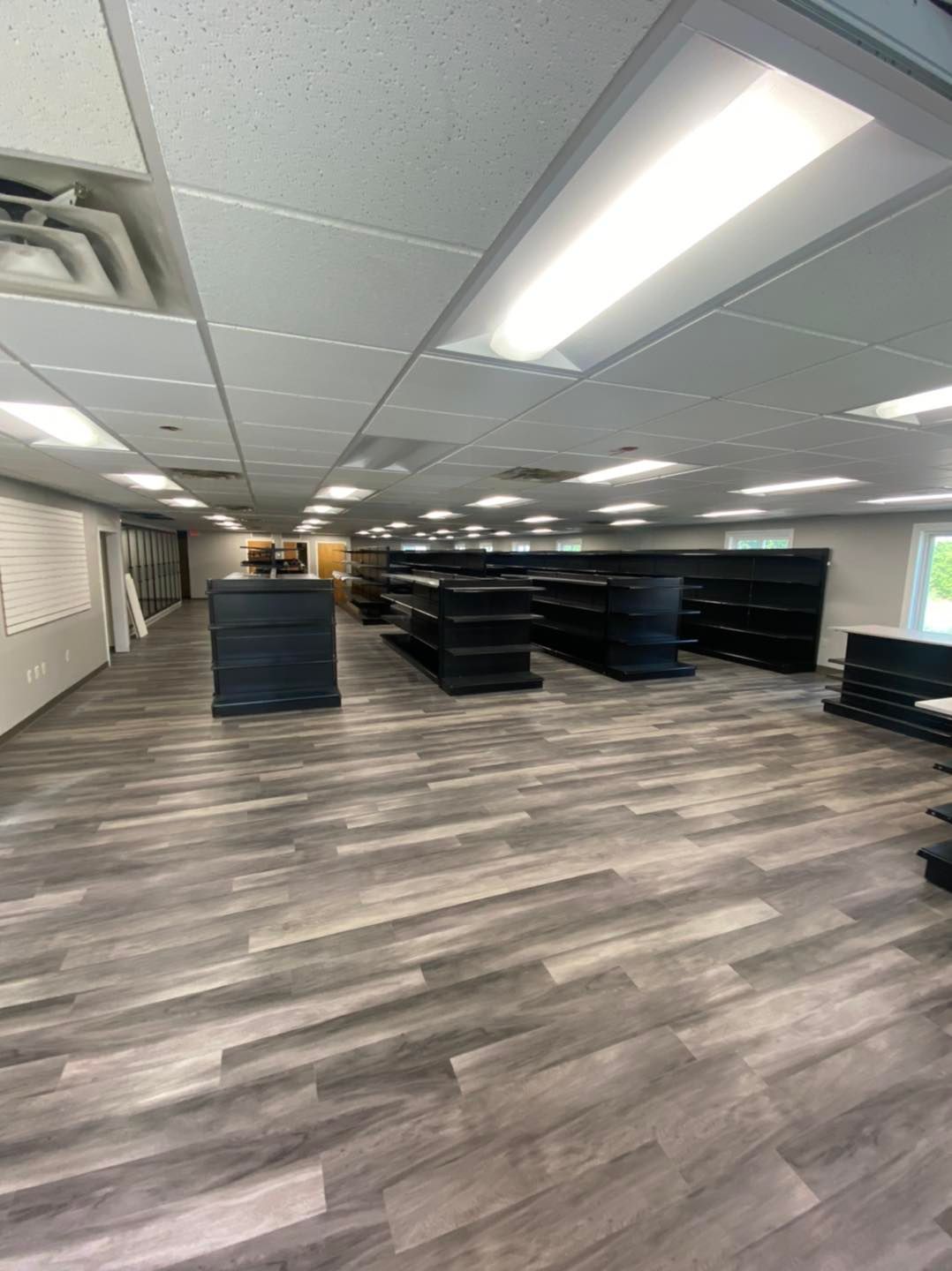A large room with a lot of shelves and a wooden floor.