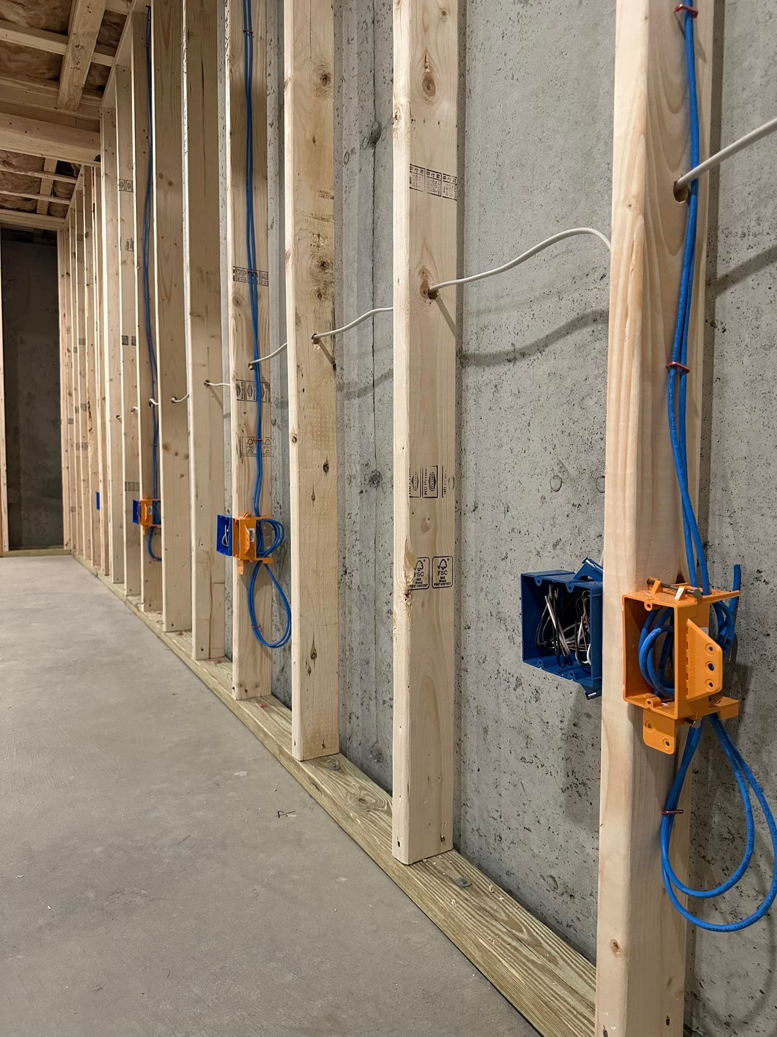 A row of wooden beams with blue wires hanging from them.