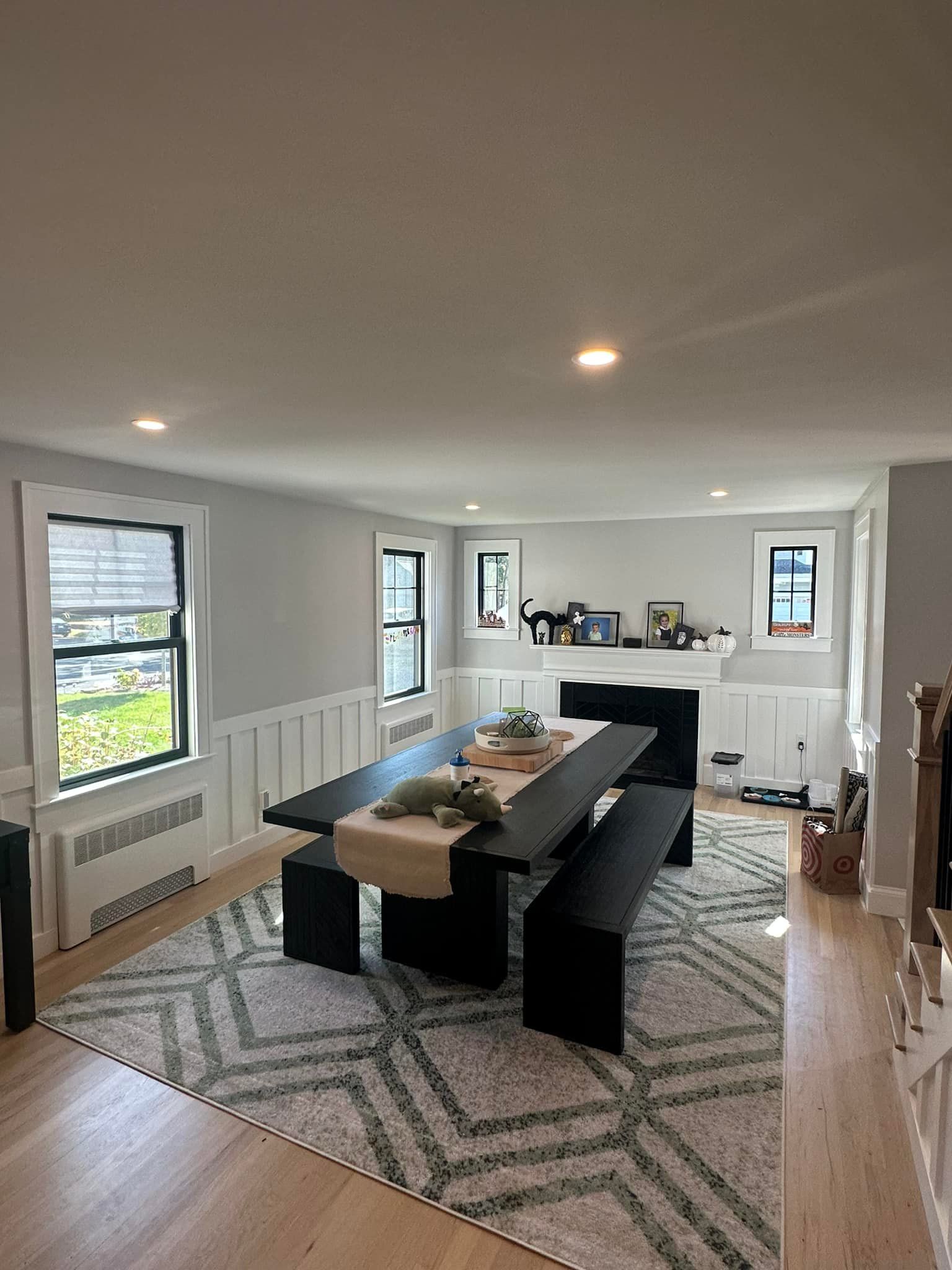 A living room with a table, benches, and a fireplace.