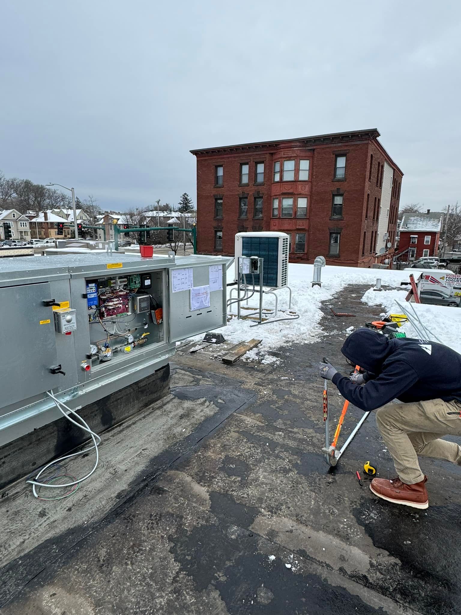 A man is kneeling down in front of a building in the snow.