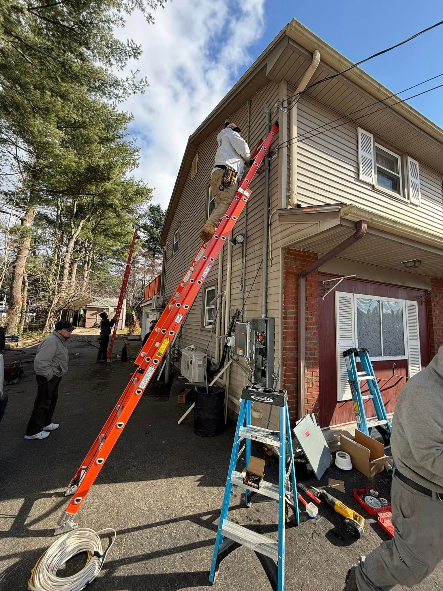A man is standing on a ladder in front of a house.