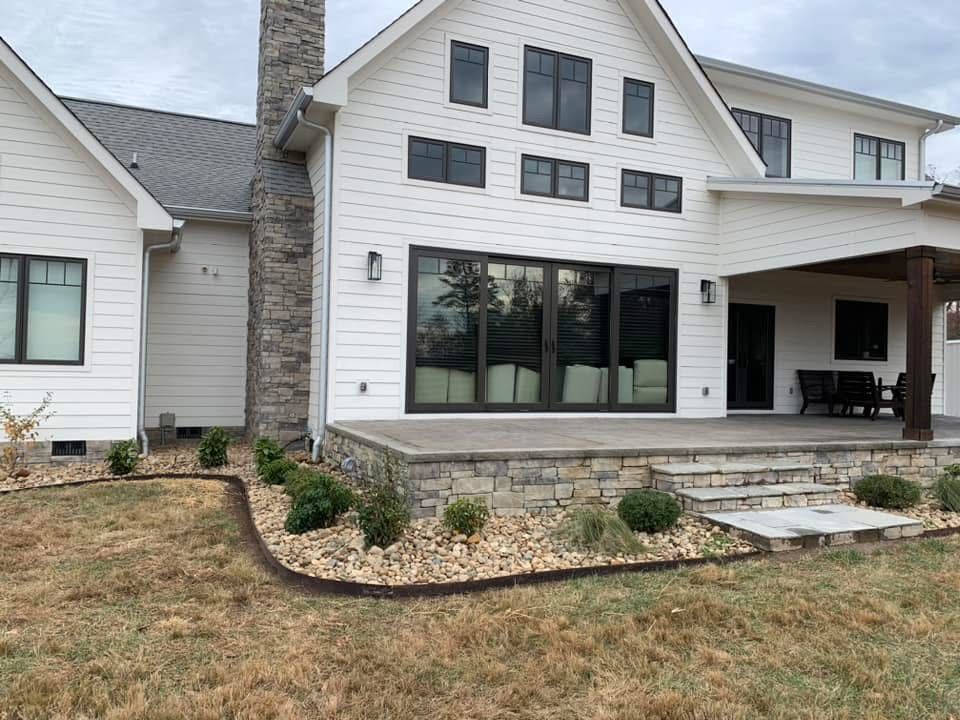 A wooden deck with a table and chairs next to a pool.