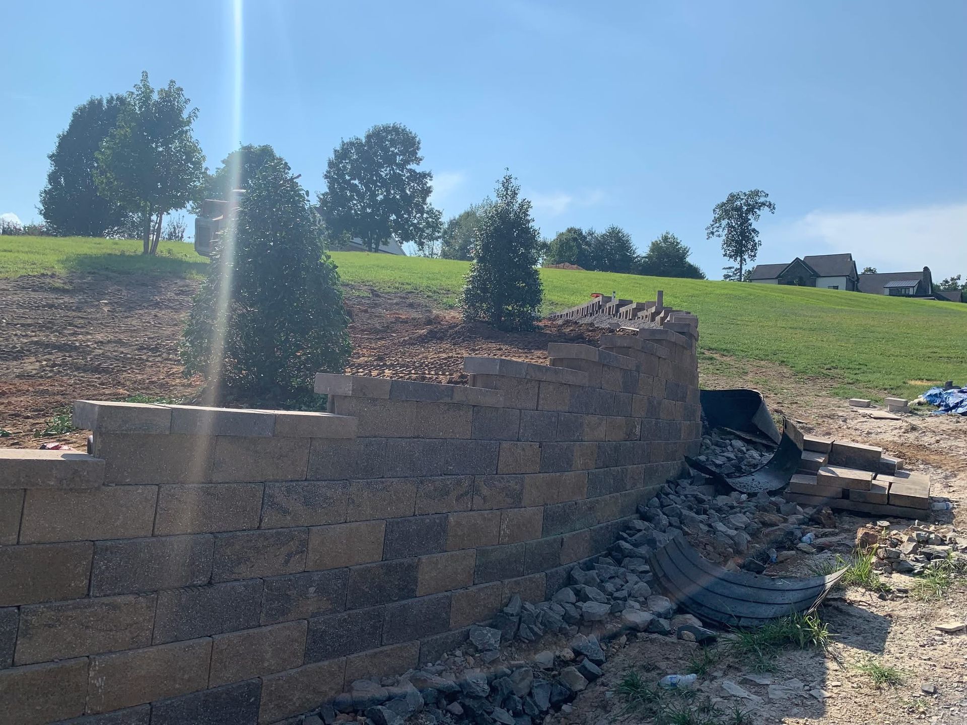 A brick wall is being built on top of a hill.