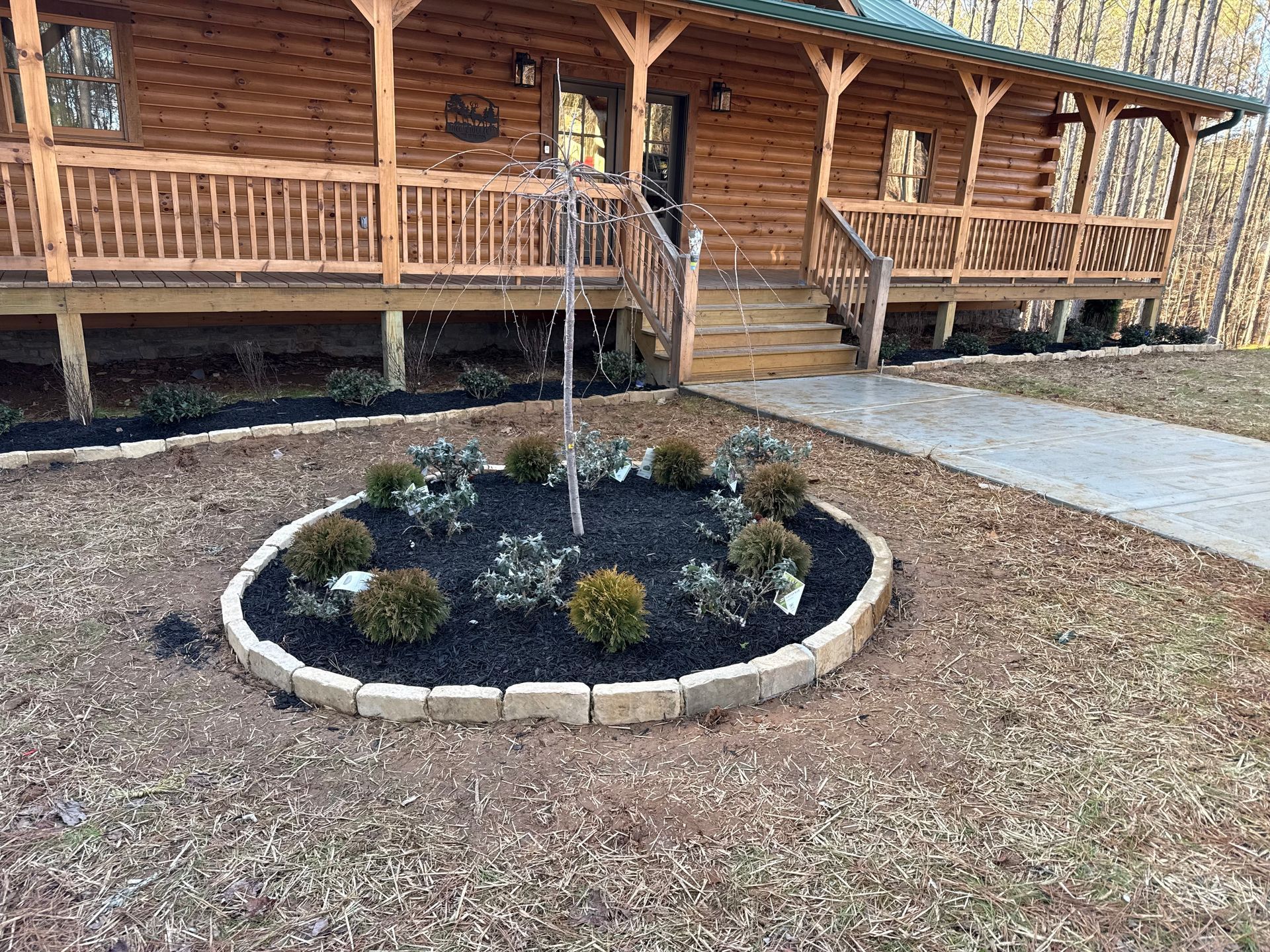 A log cabin with a circular garden in front of it.