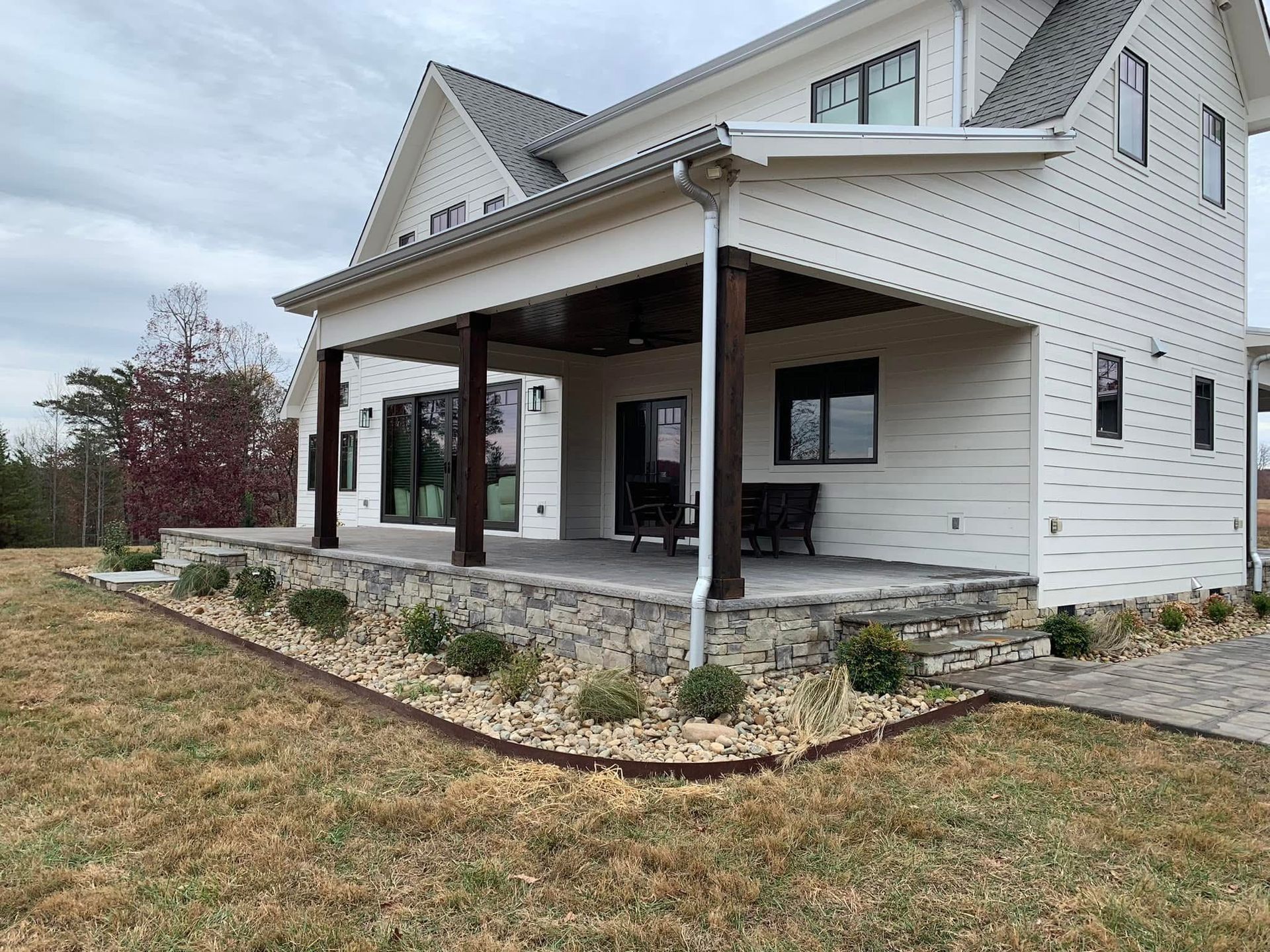 A white house with a large porch and a lot of windows.