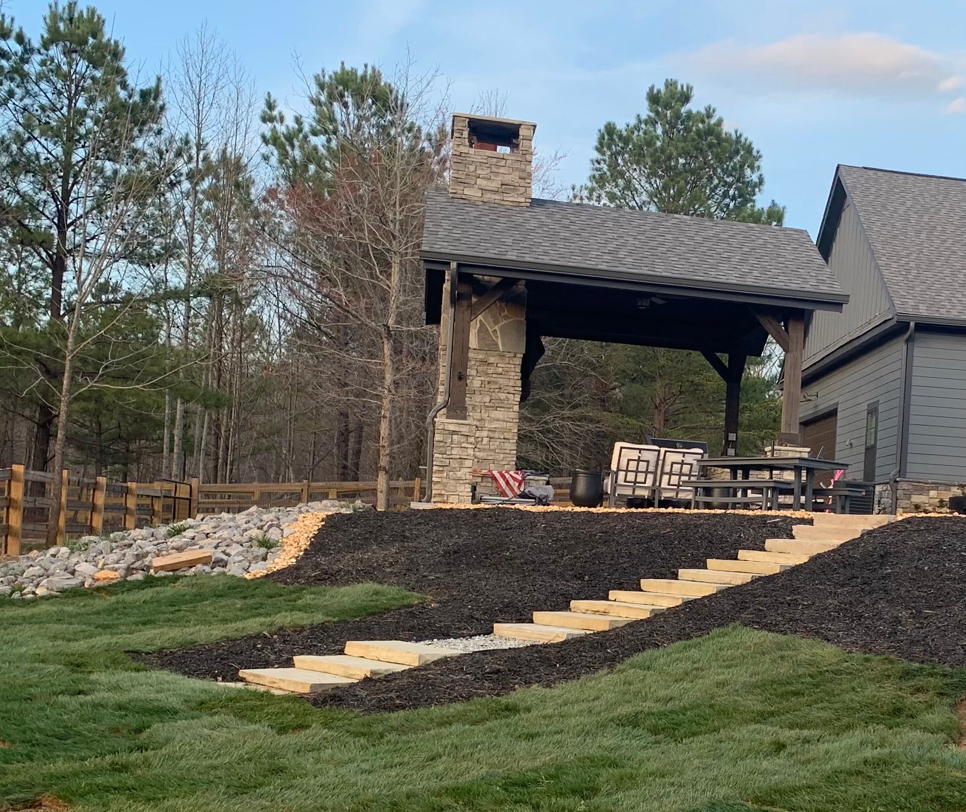 A house with a pavilion and stairs leading up to it.