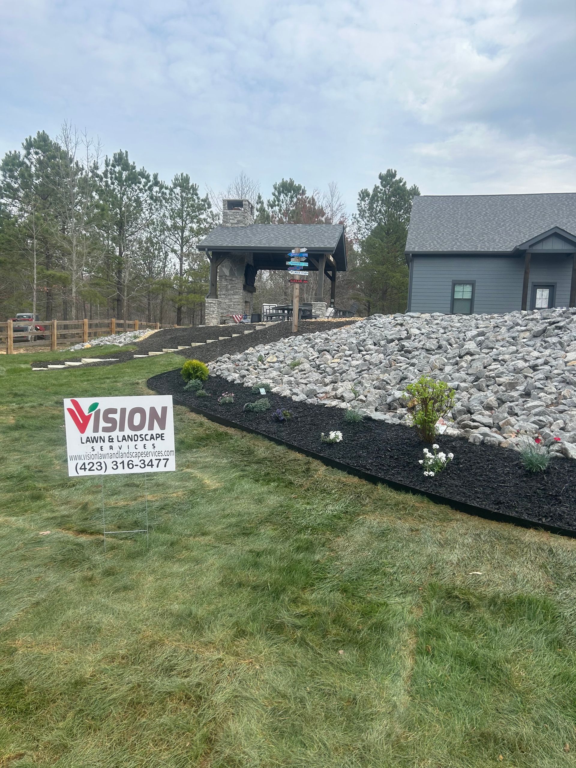 A house with a sign in front of it that says vision landscaping.