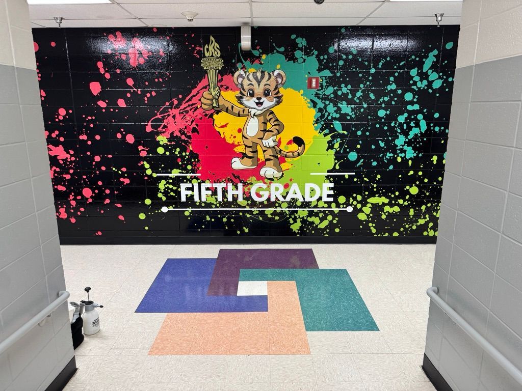 Hallway entrance with a tiger mascot on a colorful paint splatter vinyl wall wrap that says
