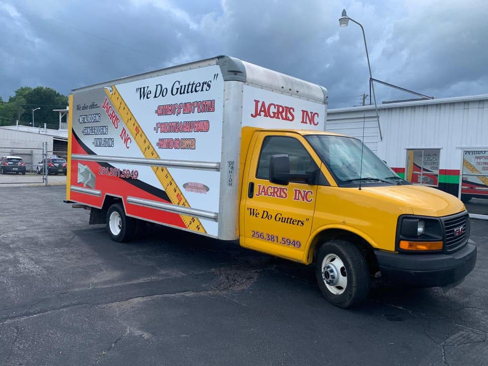 A yellow and white truck is parked in a parking lot.