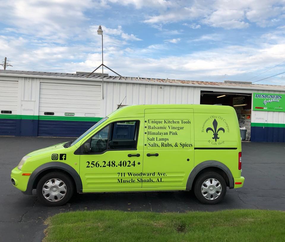 A yellow van is parked in front of a building