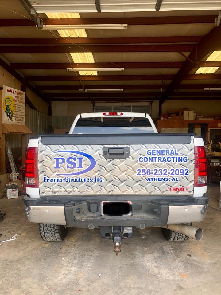 A truck is parked in a garage with a sticker on the back that says general contracting.