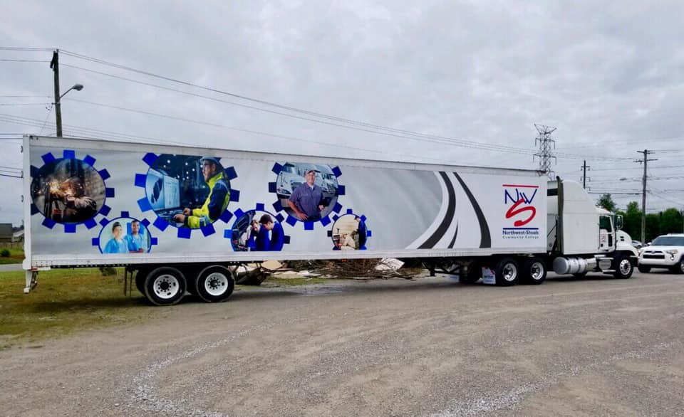 A white semi truck is parked in a parking lot.