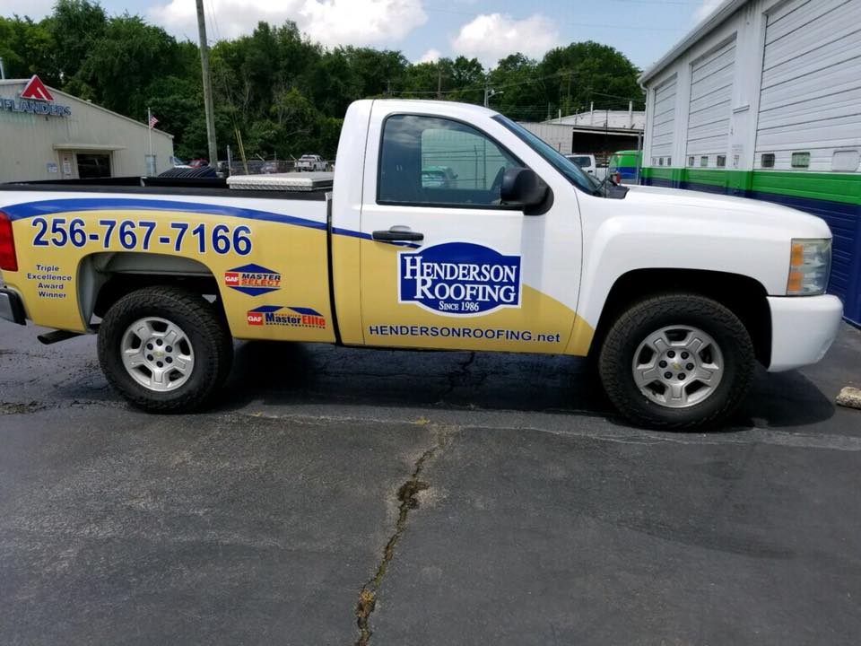 A white truck with a yellow sticker that says henderson roofing