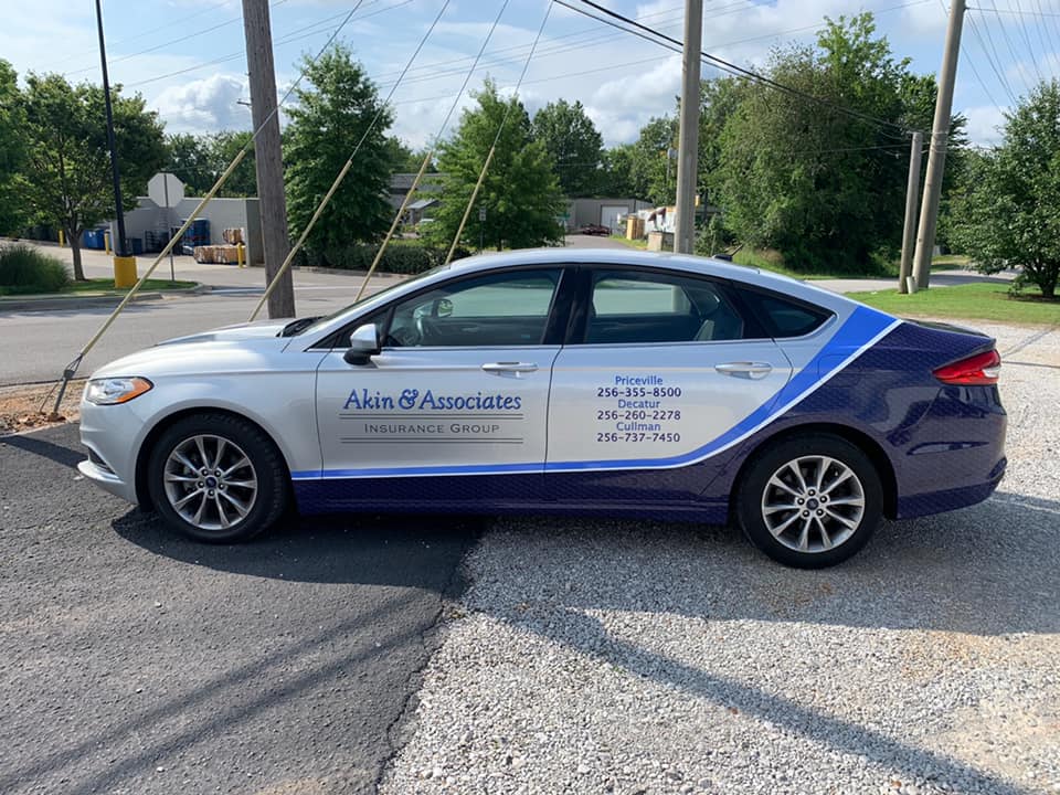 A white and blue car is parked on the side of the road.