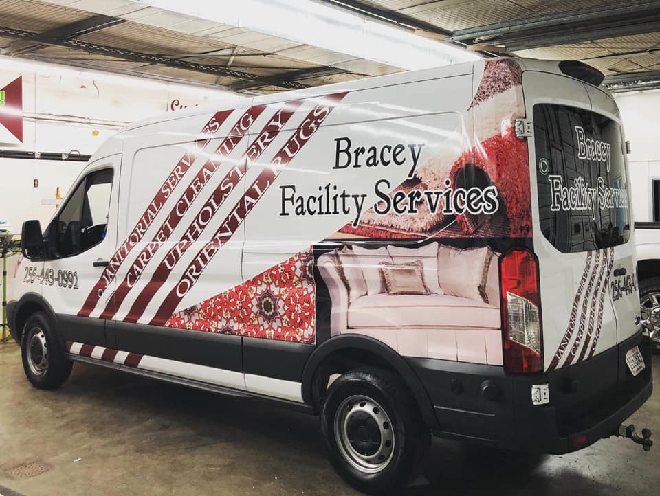 A bracey facility services van is parked in a garage