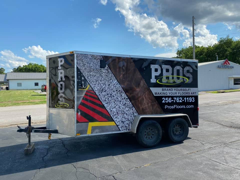 A trailer with the word pros on it is parked in a parking lot.