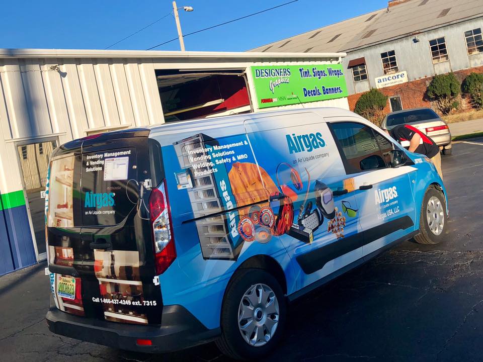 A blue and white van with the word norges on the side is parked in a parking lot.