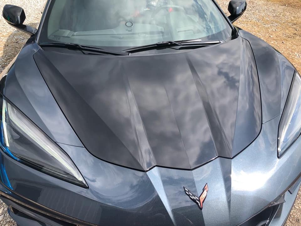 A close up of the hood of a black sports car