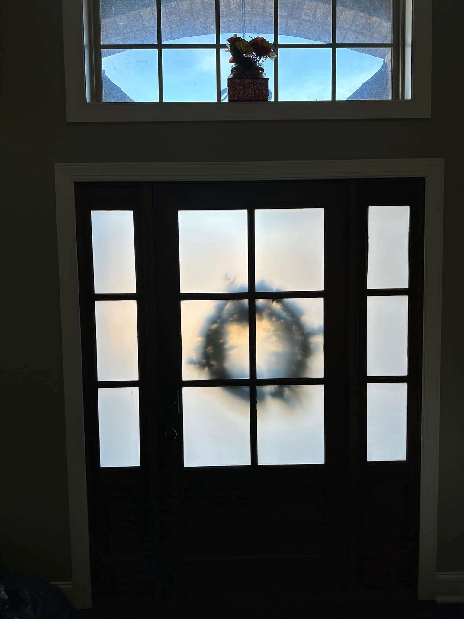 a door with a wreath on it and a window behind it