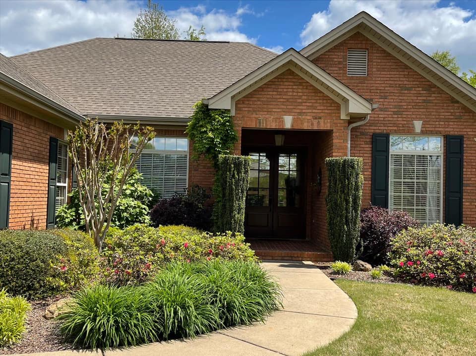 A brick house with a walkway leading to the front door