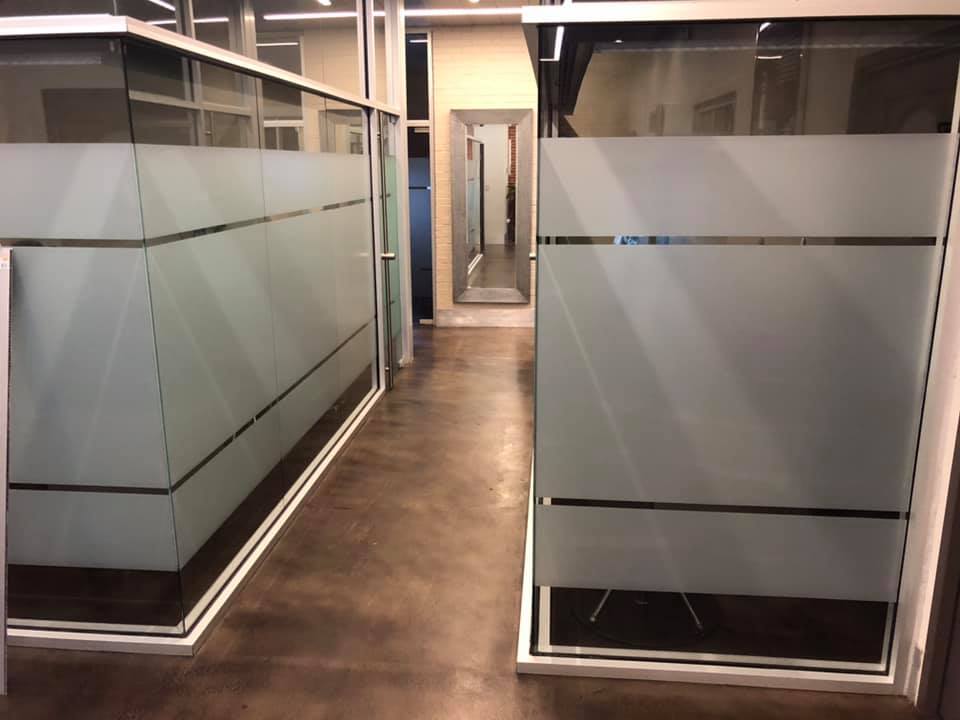 A hallway with a lot of glass walls and dividers