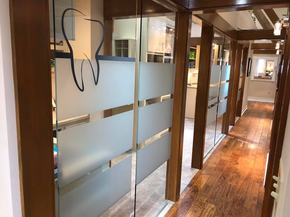 A hallway in a dental office with a tooth on the glass.