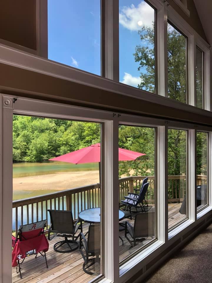A large window with a view of a deck and a lake