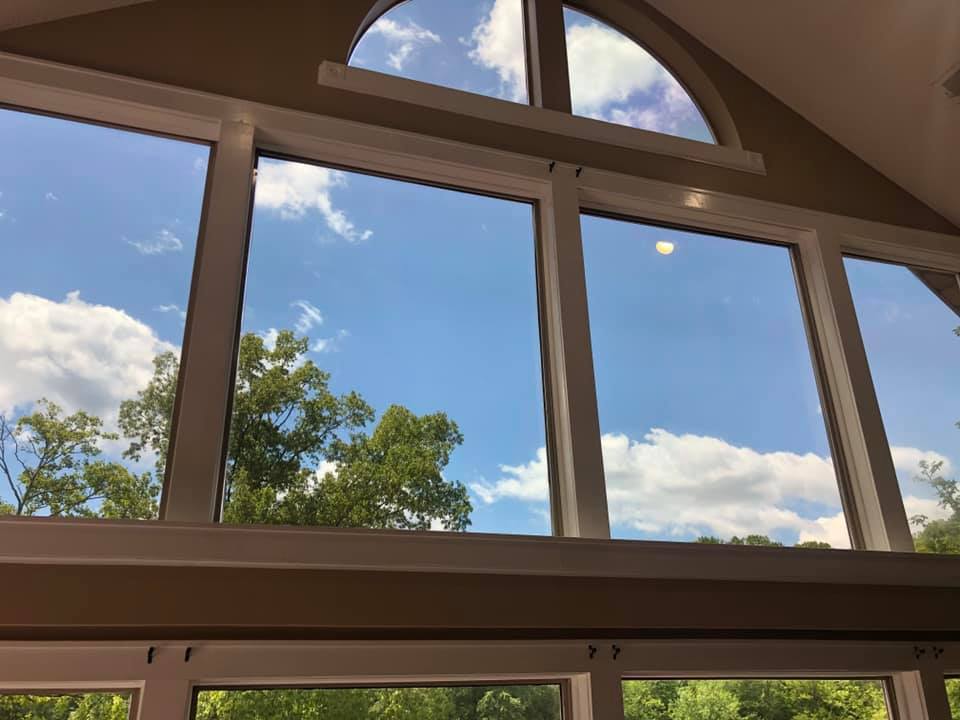 A large window with a blue sky and clouds reflected in it.
