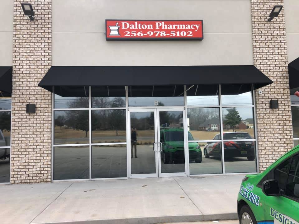 A dalton pharmacy with a car parked in front of it