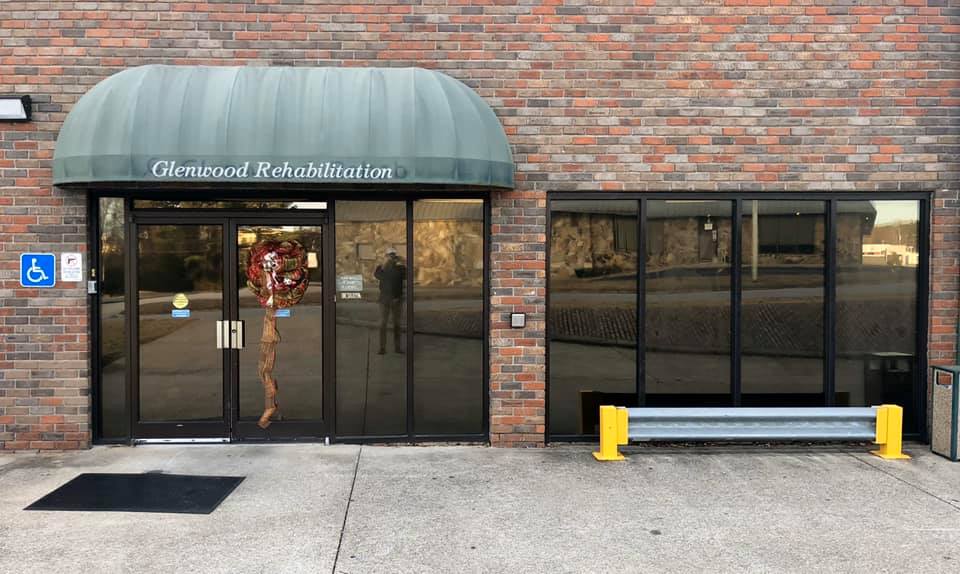 A brick building with a green awning and a handicap sign.