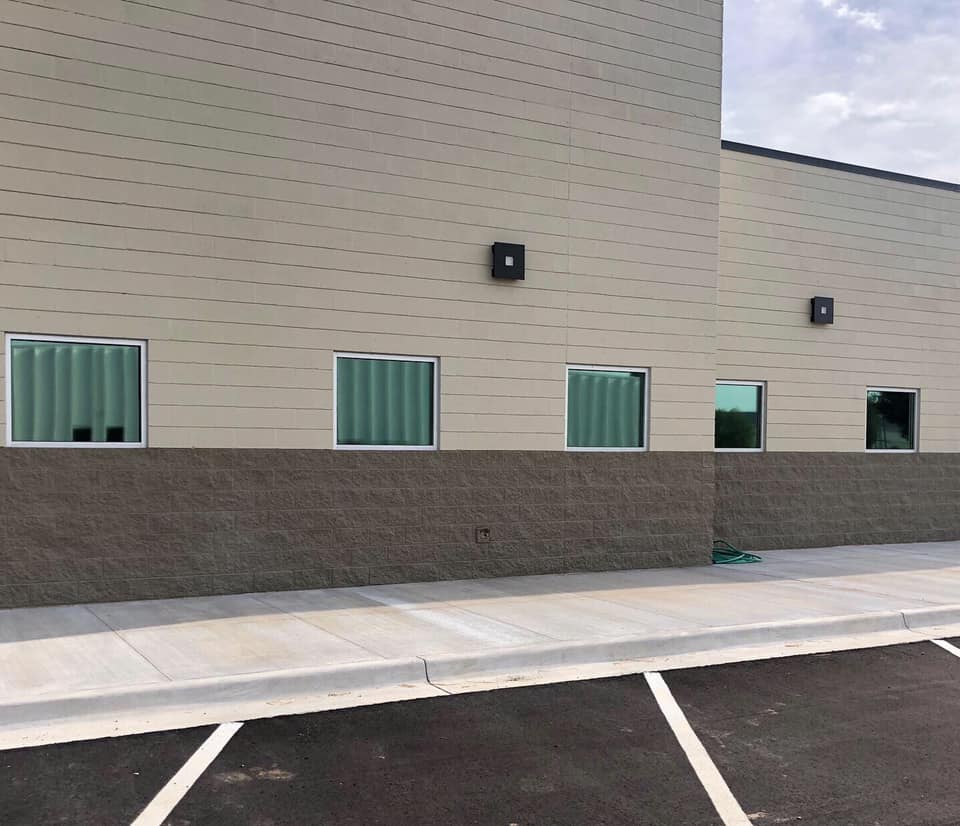 A building with a lot of windows and a parking lot in front of it