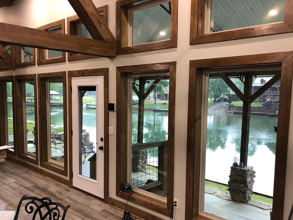 A living room with a lot of windows overlooking a lake.